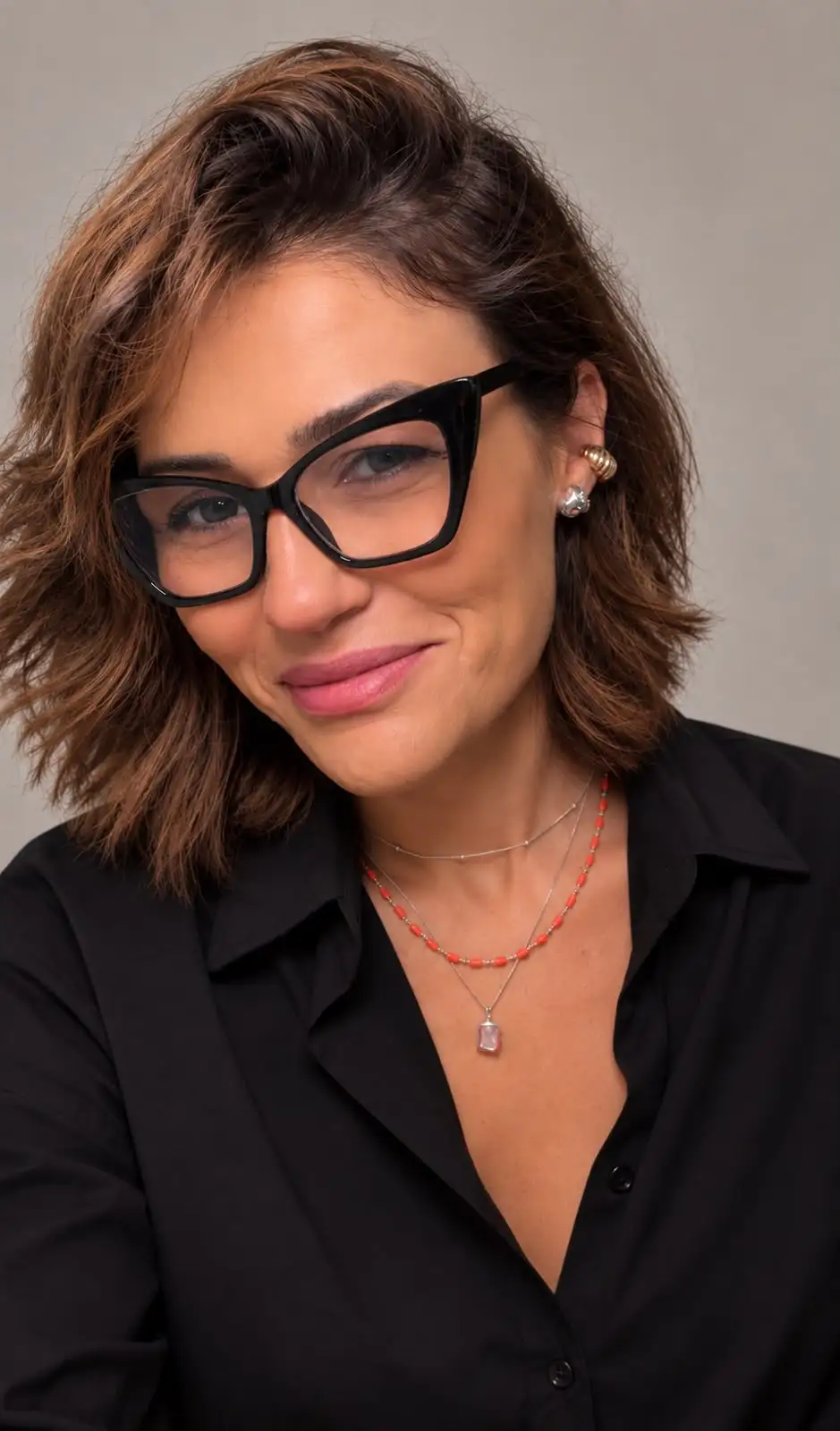 Carolina Mateo, psicóloga, sorrindo, de óculos e camisa preta